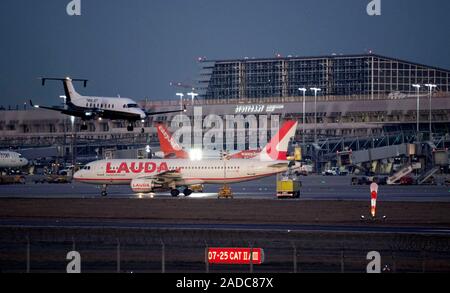 Stuttgart, Deutschland. 04 Dez, 2019. Ein Flugzeug landet am Flughafen Stuttgart, Terminal 1 des Flughafen Gebäude ist im Hintergrund sichtbar. (Dpa "trotz Klimadebatte: Flughafen Stuttgart Rubrik für record') Credit: Marijan Murat/dpa/Alamy leben Nachrichten Stockfoto