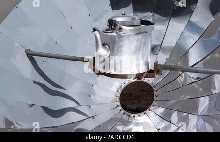 Heizung der Teekanne in einem Solarkocher im Hochland des Himalaya, Nepal. Nutzung erneuerbarer Energie; Ökologie Konzept Stockfoto