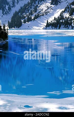 Herbst gibt Weg für Winter, Lufttemperatur sinkt und das Wasser in den See beginnt zu frieren. Textur und Muster von Eis auf dem ruhigen Wasser Oberfläche Stockfoto