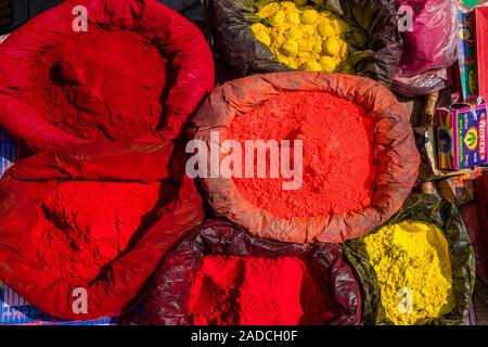 Rote, orange und gelbe Farbe Pulver in kleinen Säcken zum Verkauf auf dem Wochenmarkt Stockfoto