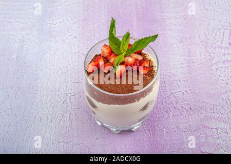 Tiramisu - köstliche hausgemachte italienische süße Nachspeise dekoriert mit Minze und eine frische Erdbeere. Stockfoto