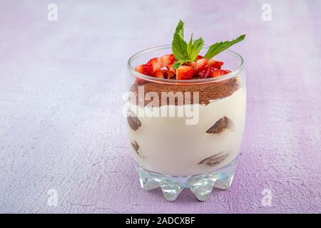 Tiramisu - köstliche hausgemachte italienische süße Nachspeise dekoriert mit Minze und eine frische Erdbeere. Stockfoto