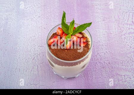 Tiramisu - köstliche hausgemachte italienische süße Nachspeise dekoriert mit Minze und eine frische Erdbeere. Stockfoto