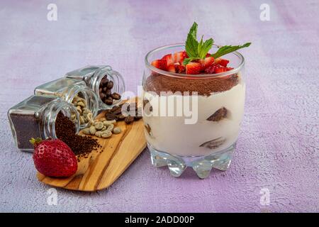 Tiramisu - köstliche hausgemachte italienische süße Nachspeise dekoriert mit Minze und eine frische Erdbeere. Stockfoto