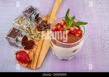 Tiramisu - köstliche hausgemachte italienische süße Nachspeise dekoriert mit Minze und eine frische Erdbeere. Stockfoto
