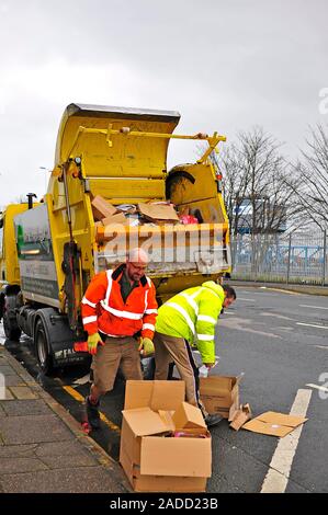 Karton-recycling Fahrzeug wird von zwei Männern in hohe Sichtbarkeit Jacken in Fleetwood, UK geladen Stockfoto