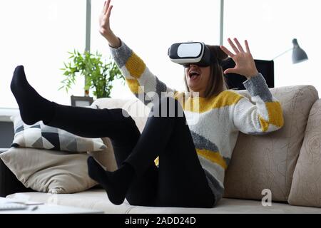 Frau sitzt zu Hause auf der Couch verwendet virtuelle Realität Stockfoto