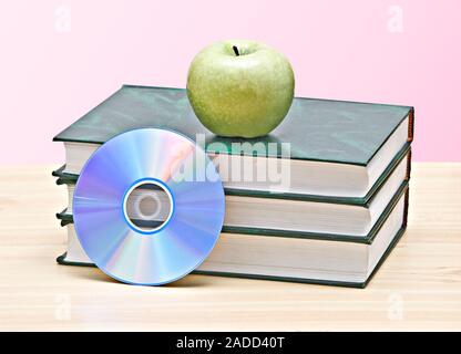 Apple, dvd, und Bücher als Symbol der Übergang von alten zu neuen Möglichkeiten des Lernens Stockfoto