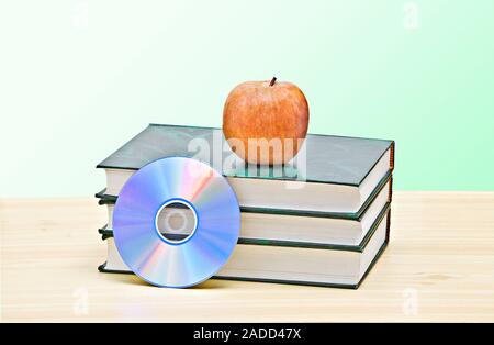 Apple, dvd, und Bücher als Symbol der Übergang von alten zu neuen Möglichkeiten des Lernens Stockfoto