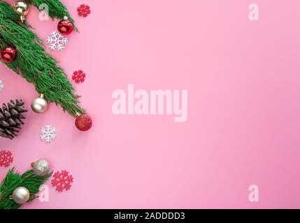 Green Pine, Pine Cone, Schneeflocken, rot Weihnachtsverzierungen Ball auf rosa Hintergrund mit Kopie Raum Stockfoto