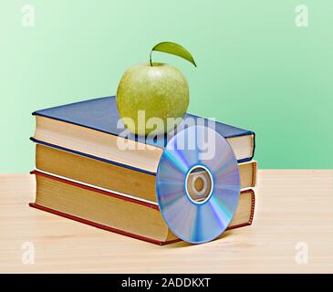 Apple, dvd, und Bücher als Symbol der Übergang von alten zu neuen Möglichkeiten des Lernens Stockfoto