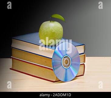 Apple, dvd, und Bücher als Symbol der Übergang von alten zu neuen Möglichkeiten des Lernens Stockfoto