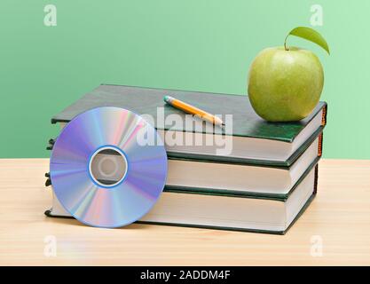 Apple, dvd, und Bücher als Symbol der Übergang von alten zu neuen Möglichkeiten des Lernens Stockfoto