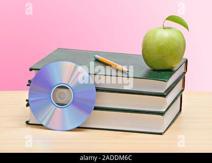 Apple, dvd, und Bücher als Symbol der Übergang von alten zu neuen Möglichkeiten des Lernens Stockfoto