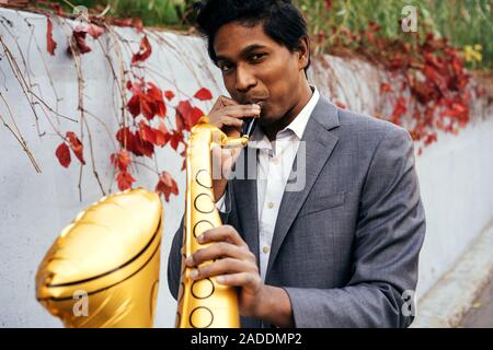 Lustig, stattlicher Mann mit einem goldenen Farbe aufblasbare Tube Stockfoto