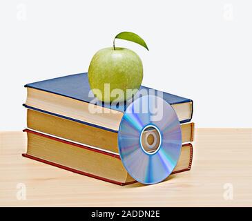 Apple, dvd, und Bücher als Symbol der Übergang von alten zu neuen Möglichkeiten des Lernens Stockfoto