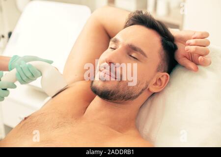 Der Mann seinen Unterarm Haar entfernt Stockfoto