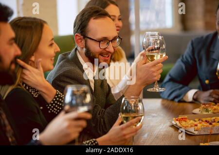 Glückliche Mitarbeiter feiern, während Unternehmen und Corporate Event. Junge kaukasier, in Geschäftskleidung zujubeln, Laughting. Konzept der Office Kultur, Teamarbeit, Freundschaft, Feiertage, Wochenende. Stockfoto