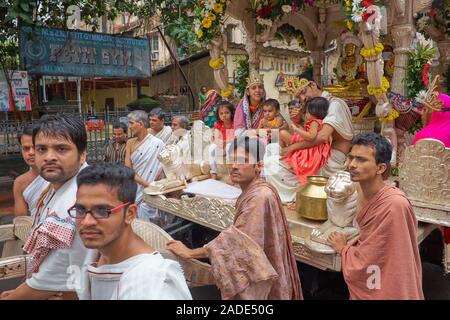 Eine Prozession der Jain-Gemeinde in Mumbai, Indien, mit einem prominenten Jain und seiner Familie, die von einem Wagen umzogen wurden Stockfoto