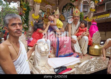 Eine Prozession der Jain-Gemeinde in Mumbai, Indien, mit einem prominenten Jain und seiner Familie, die von einem Wagen umzogen wurden Stockfoto