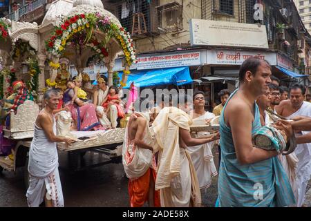 Eine Prozession der Jain-Gemeinde in Mumbai, Indien, mit einem prominenten Jain und seiner Familie, die von einem Wagen umzogen wurden Stockfoto