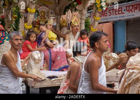 Eine Prozession der Jain-Gemeinde in Mumbai, Indien, mit einem prominenten Jain und seiner Familie, die von einem Wagen umzogen wurden Stockfoto