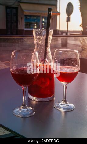 Urlaub Konzept zwei Gläser Sangria und ein Krug auf der atlantischen Küste bei Sonnenuntergang Stockfoto