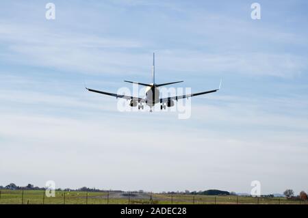 Ryanair Boeing 737-800 nähert sich der Start- und Landebahn am Flughafen zu landen, Bergerac Überquerung der Flugplatz Umzäunung. Ansicht des hinteren von Flugzeugen. Stockfoto