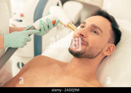 Mann, der Laser Behandlung von seinem Gesicht an der Medizinischen Klinik Stockfoto