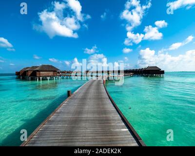 Fußgängerbrücke über flaches Wasser mit Wasser Bungalows, Insel im Süd Male Atoll, Malediven Stockfoto