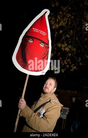 3. Dezember 2019 Trafalgar Square. Anti Trump Demonstration. Ein Mann hält ein Plakat mit Trumpf in einem roten Ku Kluk Klan stil Maske und die Wörter 'Make Ame Stockfoto