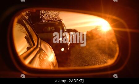 Abgase aus queuing Verkehr im Fahrzeug Außenspiegel bei Sonnenaufgang york Vereinigtes Königreich wider Stockfoto