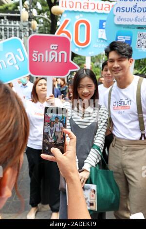 Bangkok, Thailand. 4. Dez, 2019. Beliebte thailändische Schauspieler Theeradej Wongpuapan (Kane) wird gemobbt für selfies durch verehrenden Fans, als er seinen neuesten Film Herzschläge in der Silom Bangkok fördert. Er Fans begrüßt, und gab ihnen viel Zeit, Fotos zu sich zu nehmen, als er sich der Silom Straße gelaufen und später durch einen lokalen Markt, wo er grüßte Inhaber Stall ging. Heartbeats ist am 12. Dezember veröffentlicht. Quelle: Paul Brown/Alamy leben Nachrichten Stockfoto