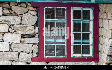 Steinmauer mit grunge Fenster in einer Berghütte Stockfoto