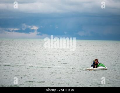 Batu Ferringhi Beach, Malaysia - November 2019: Anonyme Paar reiten Jet-ski in endlosen Ozean Wasser in das natürliche Tageslicht Stockfoto