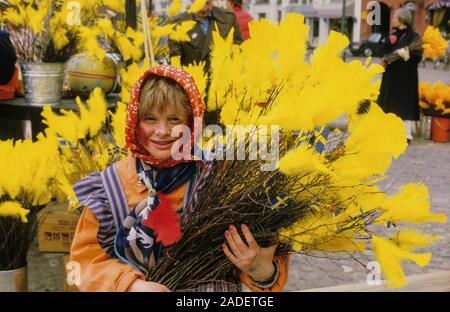 Ostern twiggs mit seinen cloloured Feder und ein junges Mädchen gekleidet wie Ostern Crone Stockfoto