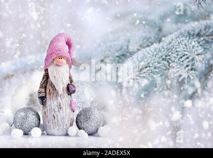 Weihnachten gnome mit festlichen Dekorationen auf einem Hintergrund verschneiten Tannenzweigen. Weihnachten oder Neujahr Grußkarte. Stockfoto