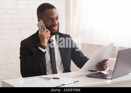 Lächelnd Mann in Anzug, Business Partner, holding Papiere Stockfoto