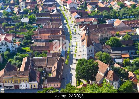 Vogelperspektive auf Straße, traditionelle Häuser, Kirchen und Uhrturm in einer rumänischen Bergstadt in Siebenbürgen. Rasnov, Kreis Brasov, Rumänien Stockfoto