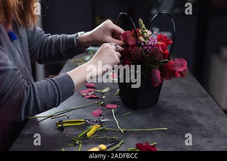 Die Hände der Floristen und verschiedene schöne Blumen. Blume Lieferung. Der Beruf des Floristen Stockfoto