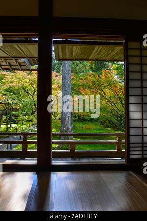 Traditionelle japanische Papier Schiebetüren und Tatami Matten Öffnen der schönen bunten Herbst anzeigen Blätter Ahorn im Garten. Stockfoto