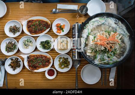 Tofu gekocht im Topf mit Gemüse Gurken und würzigen Fisch der traditionellen koreanischen Essen auf den Tisch Stockfoto