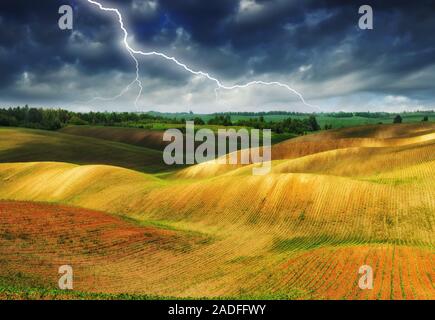 Blitz über dem Feld. malerische hügelige Feld Stockfoto