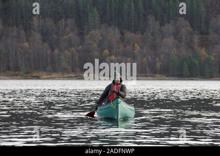 Kanufahren auf dem Loch Beinn a' Mheadhoin mit Gemeine Kiefer (Pinus sylvestris) Wald, Glen Affric, Highlands, Schottland. Stockfoto