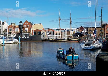 Zwei Männer in einem kleinen Boot, Hebezeuge Treibholz und Wurf aus der Marina, Hull, East Yorkshire, England, Großbritannien Stockfoto