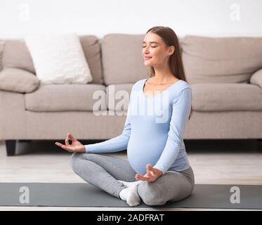 Entspannt junge schwangere Mädchen meditieren auf dem Boden Stockfoto