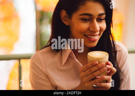 Ruhige Dame genießen leckere Latte und lächelnd Stockfoto