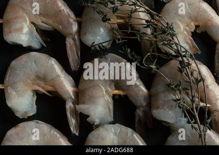 Zweige Thymian auf rohe Garnelen Spieße Stockfoto