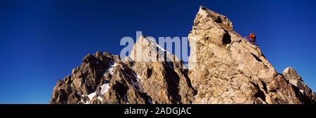 Low Angle View eines Mannes auf einen Berg klettern, Rockchuck Peak, Grand Teton National Park, Wyoming, USA Stockfoto