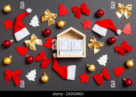 Blick von oben auf die Holz- Kalender auf schwarzen Hintergrund mit neuen Jahr Spielzeuge und Dekorationen. Die Zwanzig 5. Dezember. Weihnachten Konzept. Stockfoto
